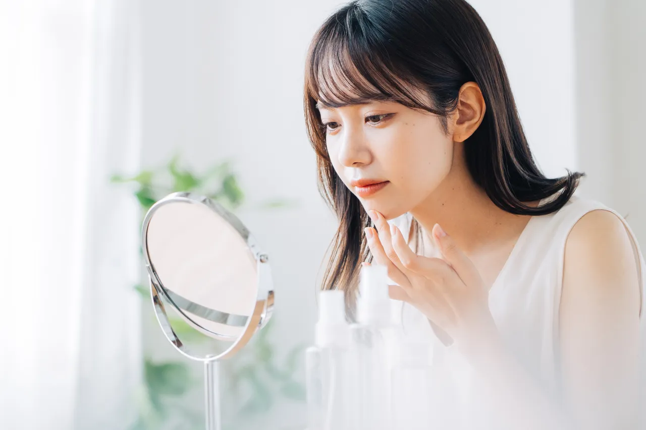 鏡で鼻まわりの肌を確かめる女性