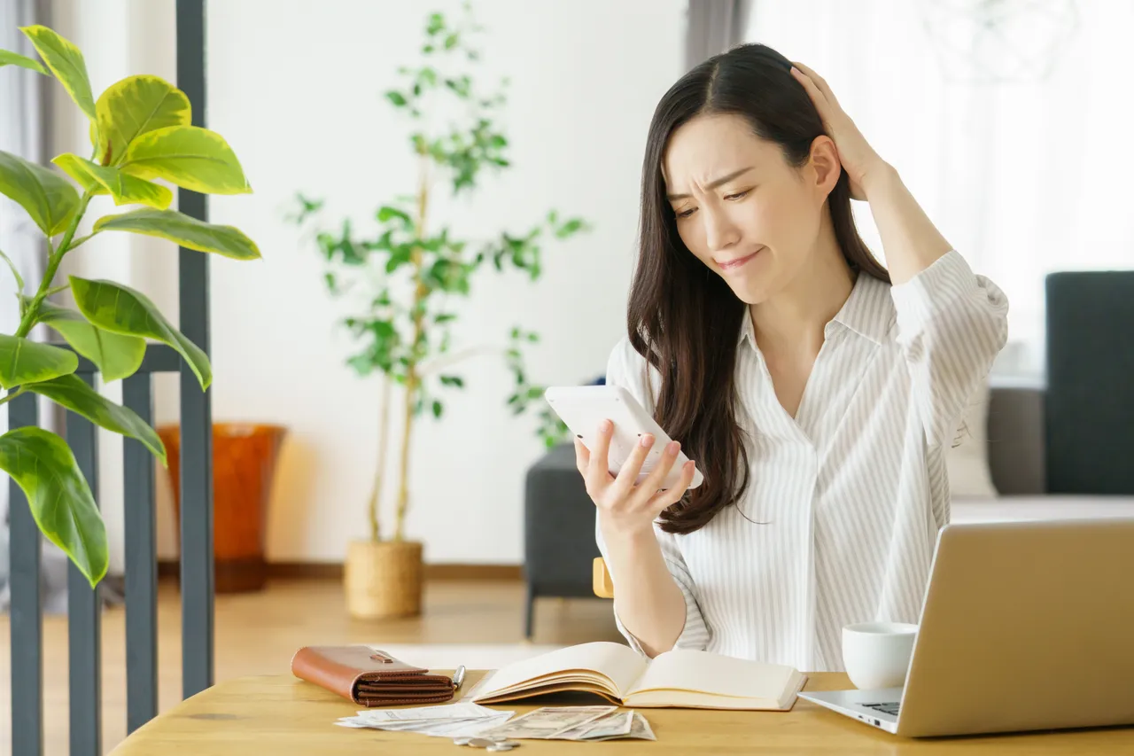 電卓を見ながら料金を考える女性