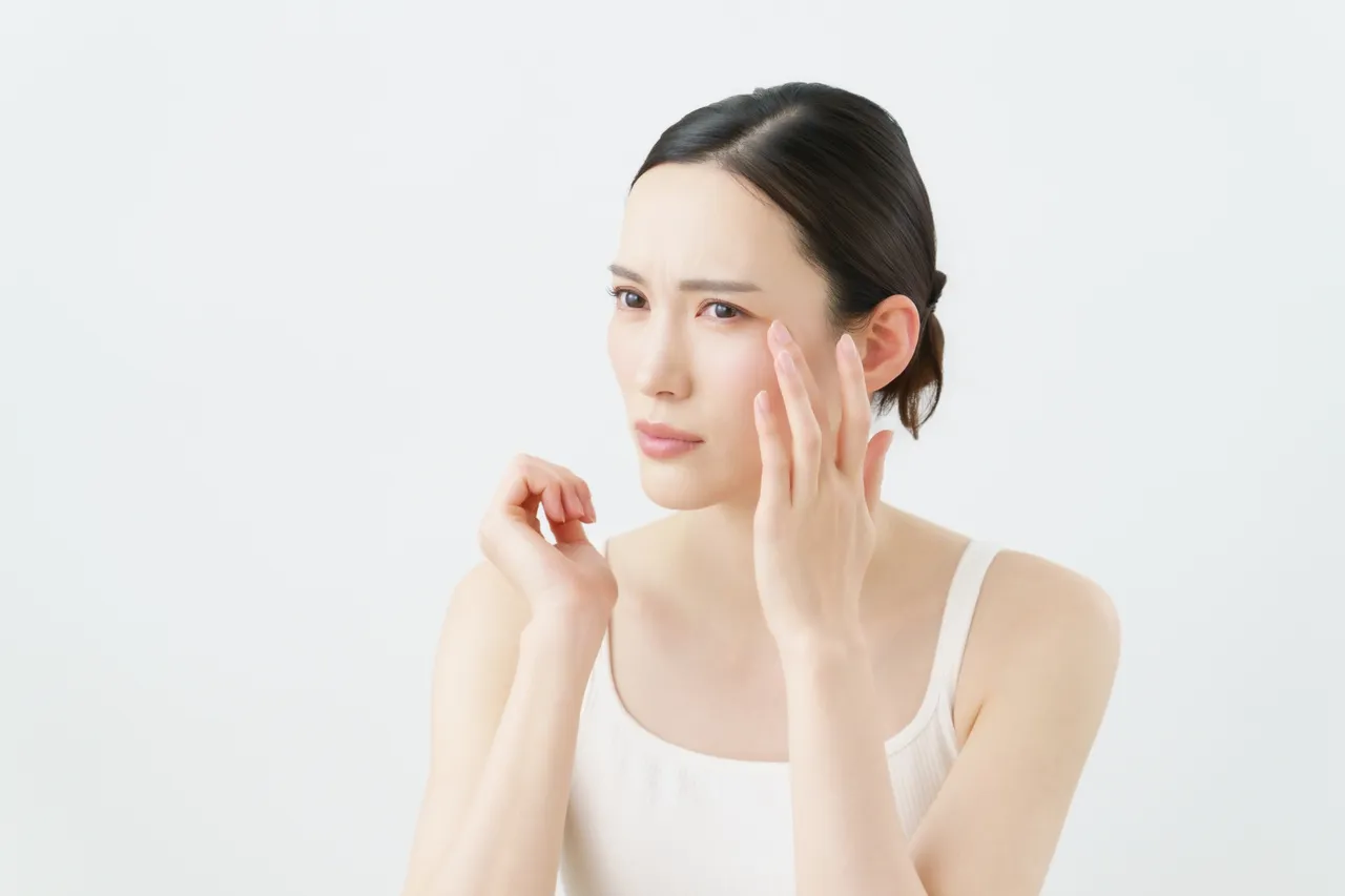 不安そうに顔を触る女性