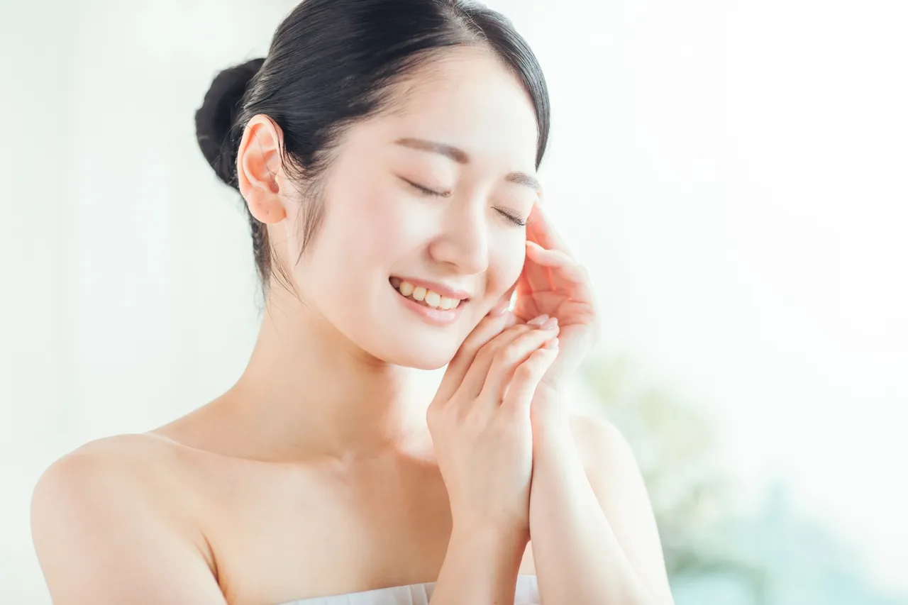 目を細めて頬に手を添える女性