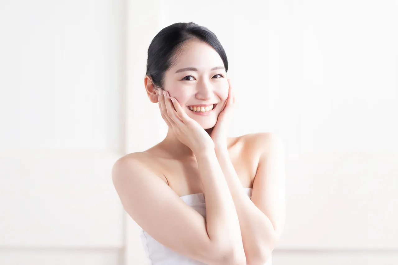 笑顔で頬に手を添える女性