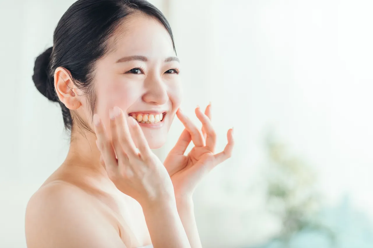 頬に手を添えてほほえむ女性
