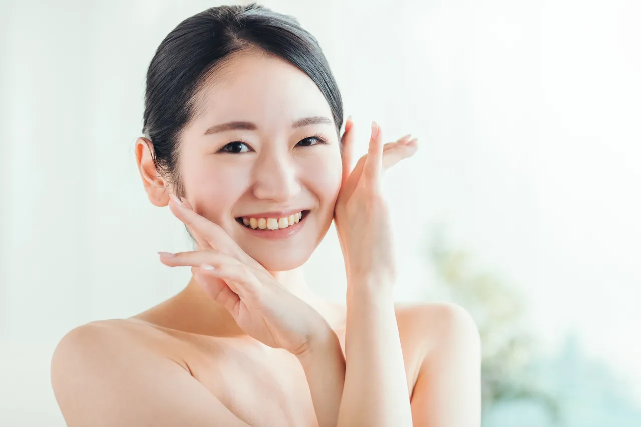 笑顔で頬に手を添える女性