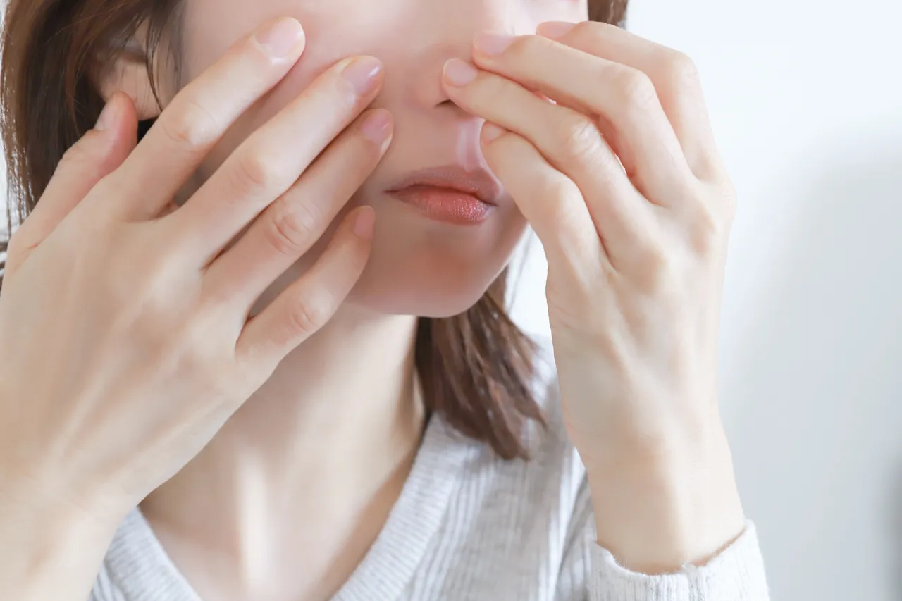 鼻に手を添える女性