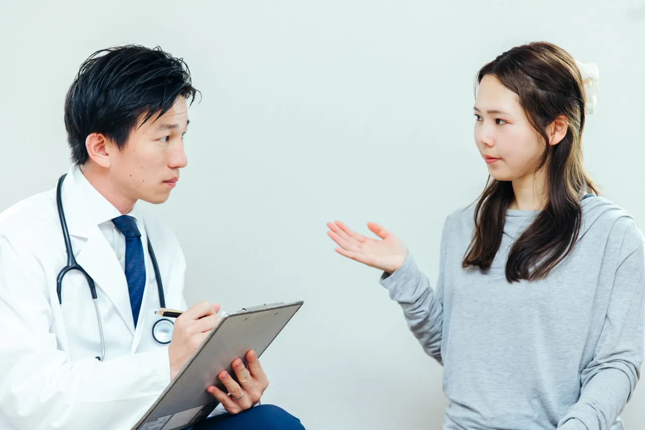 医師のカウンセリングで質問する女性