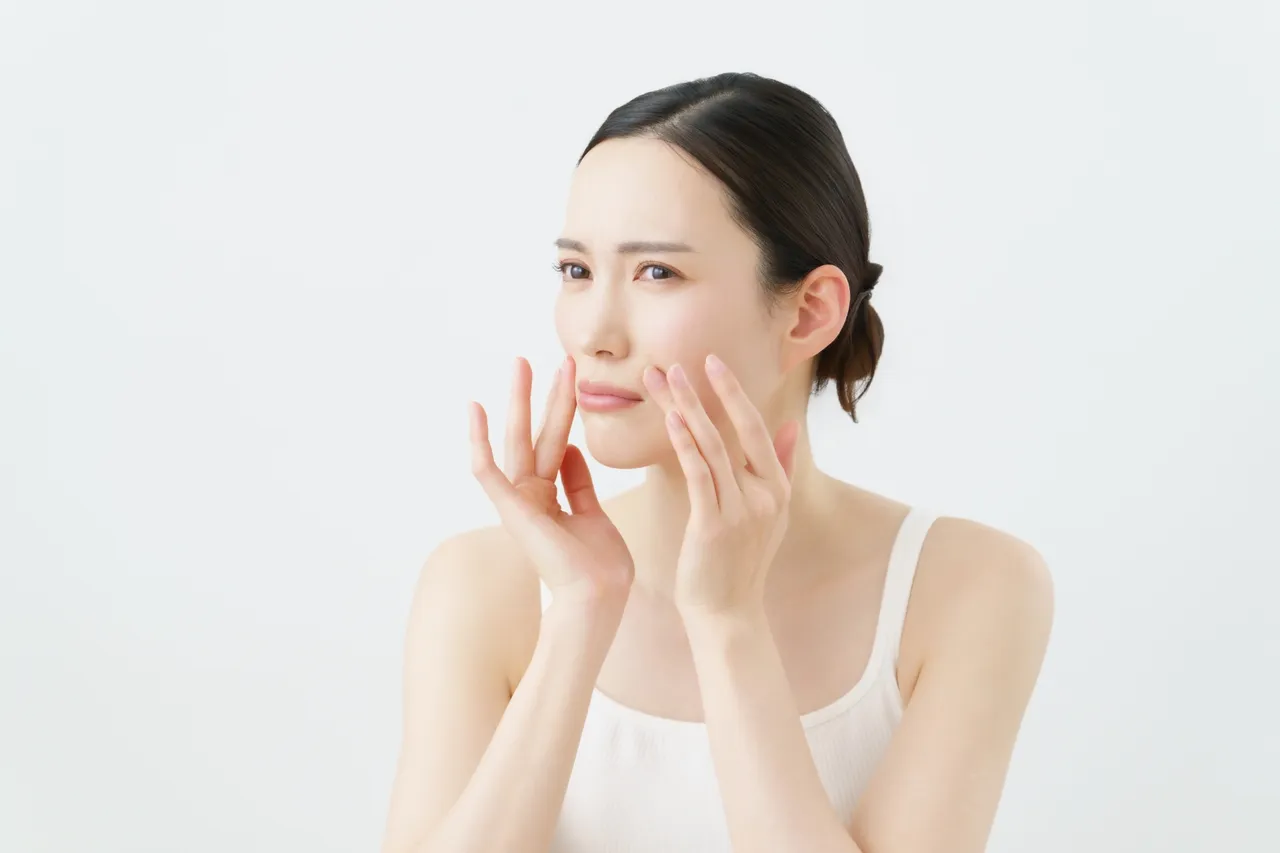 頬に手を当てて悩む女性