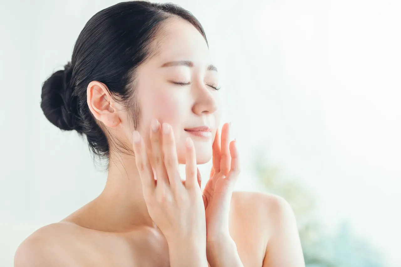 目を閉じて頬に手を添える女性の横顔