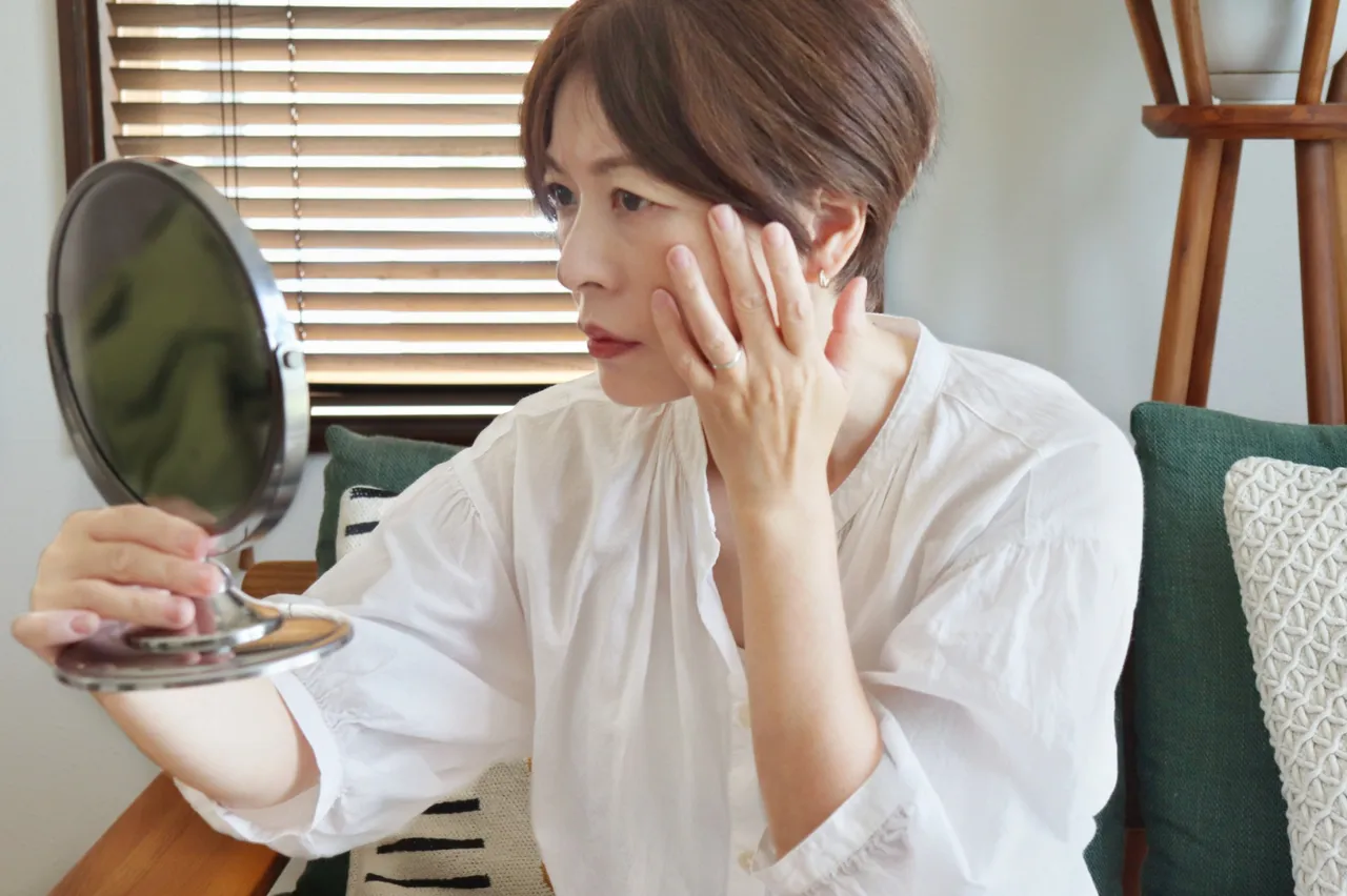 手鏡で顔の変化を確かめる女性