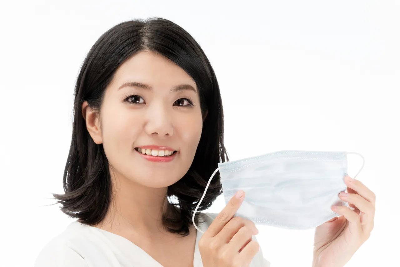 マスクを外して笑顔を見せる女性