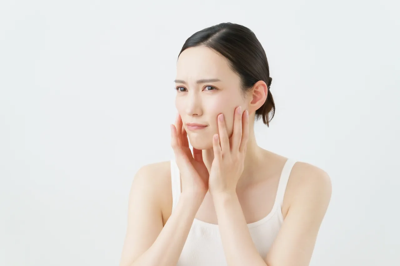 不安そうに頬に手を当てる女性