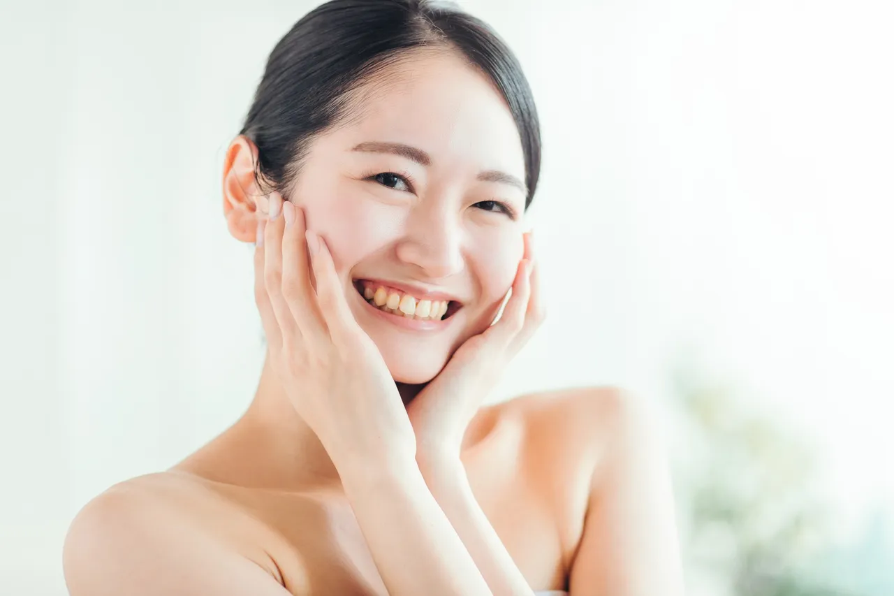 頬に手を添えてほほえむ女性