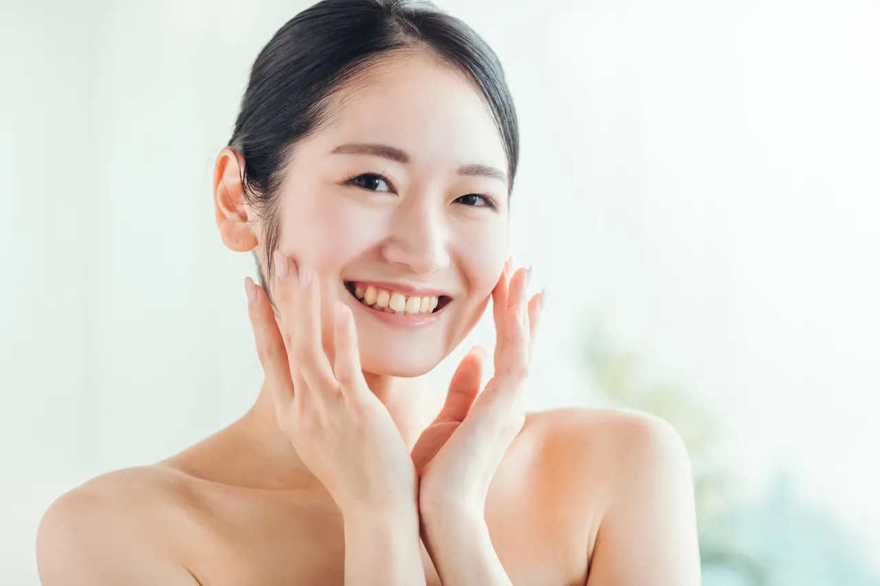 笑顔で頬に手を当てる女性