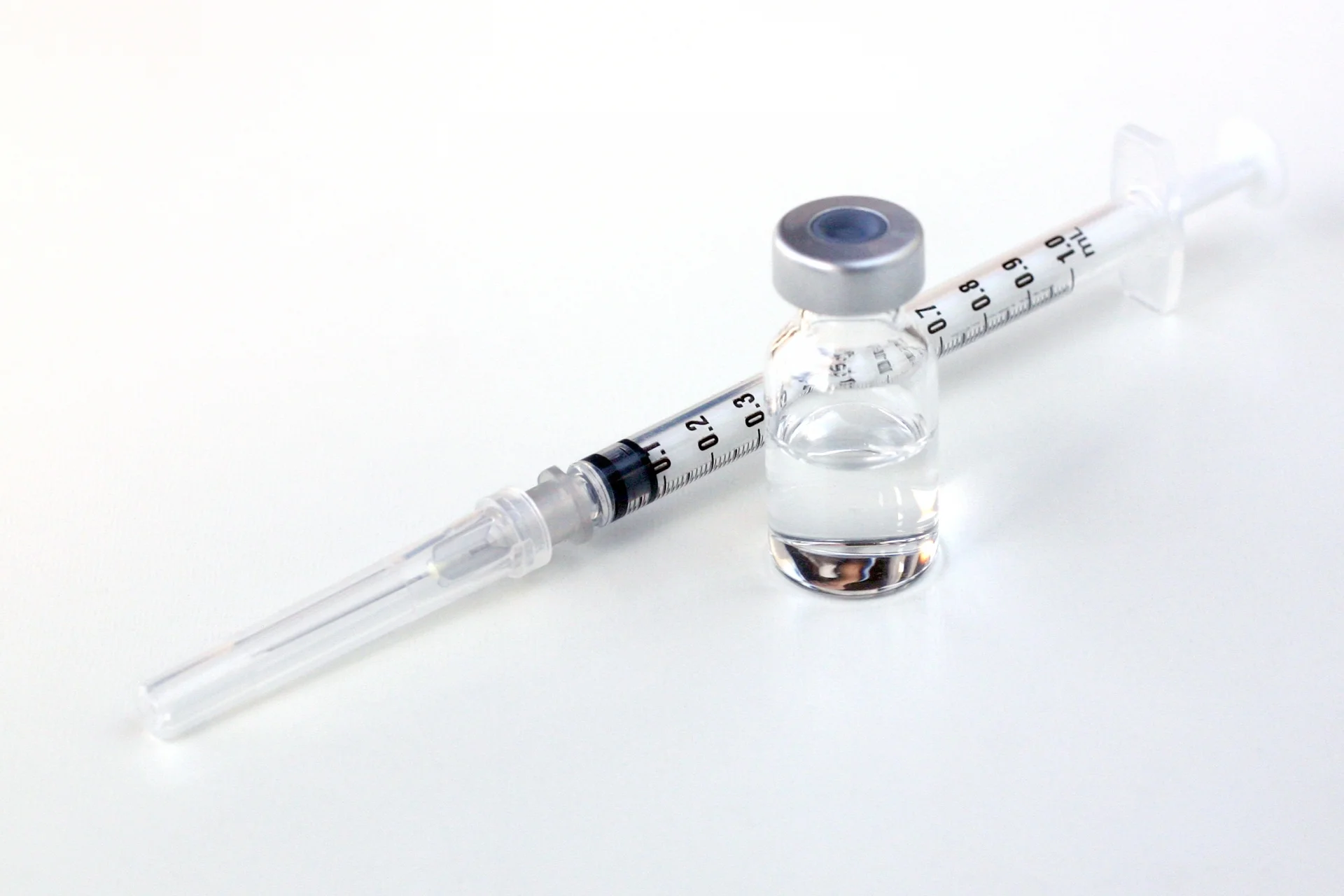 白い台の上に置かれた注射器と薬液の小瓶