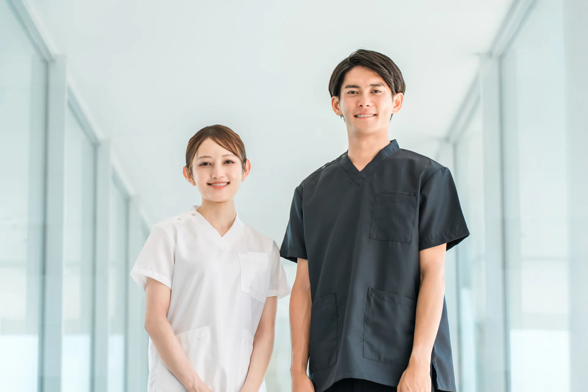 並んで立つスクラブ姿の男性医師と白衣の女性スタッフ（医師に原因を確かめるイメージ）