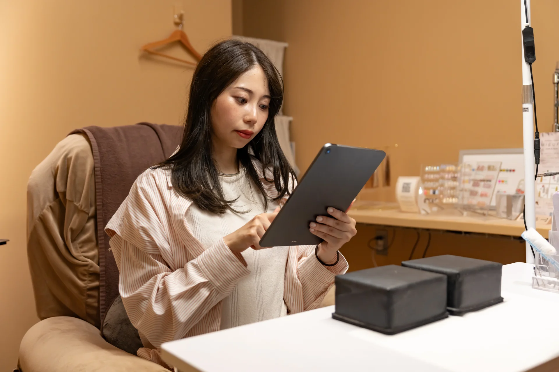 椅子に座ってタブレットを見る女性